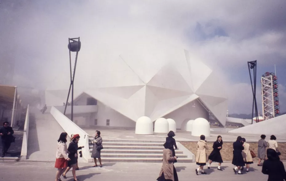 Photographie rétro de l’exposition universelle de 1970 avec le pavillon Fuji enneigé et des visiteurs en manteaux.